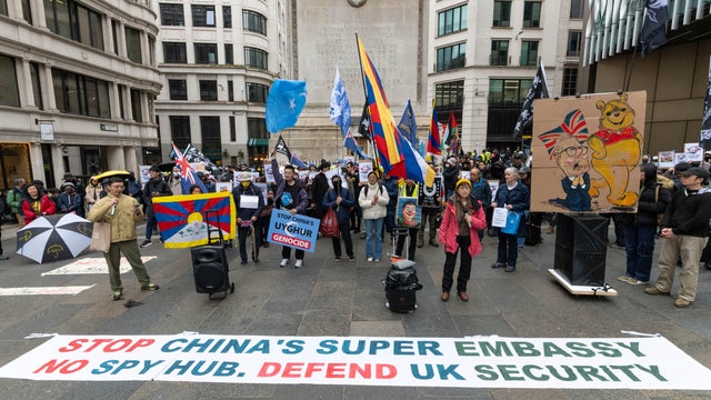 Protesters gathered next to a banner saying "Stop China's 