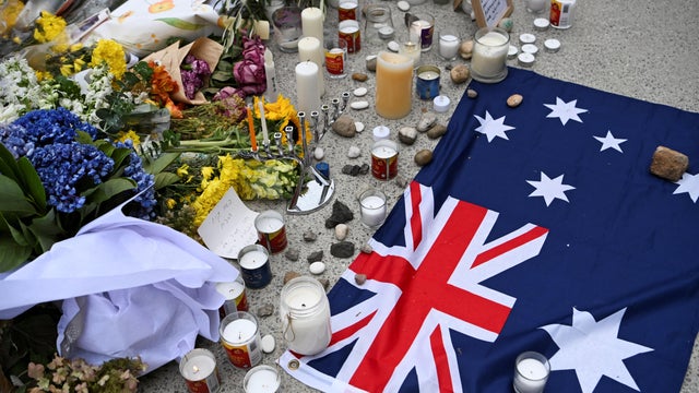 An Australian flag is placed near flowers laid as a tribute to honor the victims of a terror attack that targeted a Hanukkah celebration at Bondi Beach in Sydney, Australia, Dec. 16, 2025. 