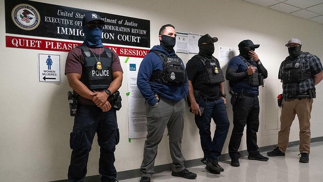 Federal law enforcement officers stand outside immigration courtrooms at the Javits Federal Building in New York on Nov. 21, 2025. 