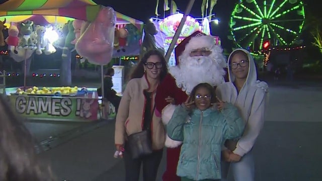 A family poses in front of Santa Claus at Christmas at the Fair in Stockton 