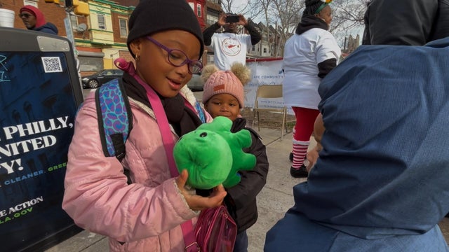 A girl looks at a toy she received on Christmas 