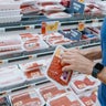 Man Checks Price of Ground Beef at Supermarket 