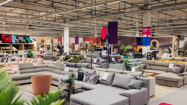 Furniture store with many sofas, armchairs and other furniture in different colors and materials 
