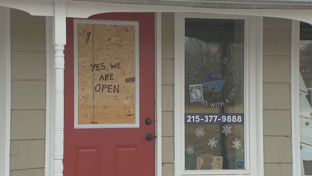 A window is boarded up in the door at Voltage Bikes in Upper Makefield Township 