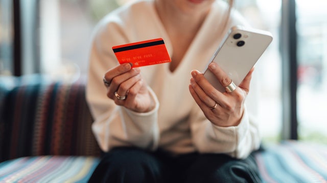 Young Asian woman making card payment via smartphone 