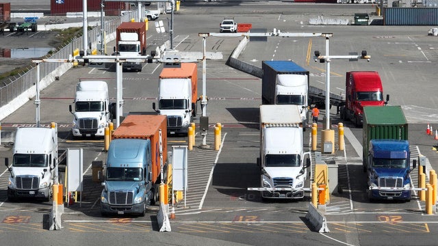 Trucks line up to leave a shipping terminal at the Port of Oakland on March 31, 2023. 