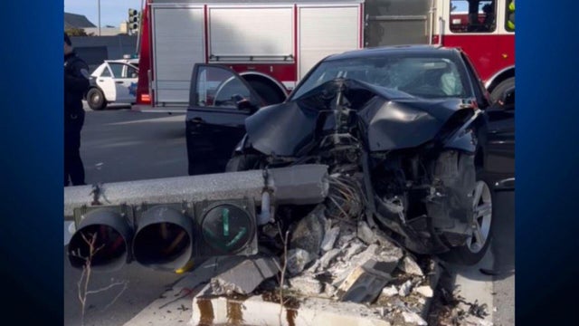 The front of a car smashed against a light pole 