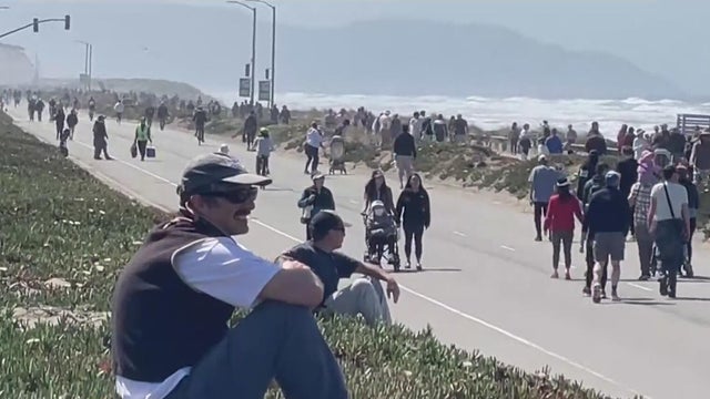 People walk in Sunset Dunes on a closed part of the Great Highway 
