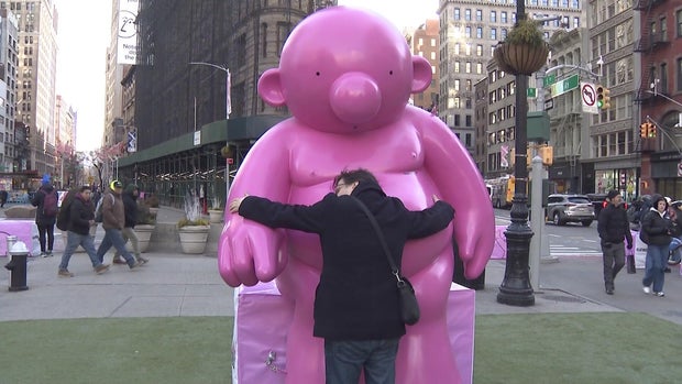 Visitor hugging Mr. Pink sculpture 