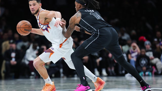 Devin Booker #1 of the Phoenix Suns looks on as Terance Mann #14 of the Brooklyn Nets defends during the fourth quarter of the game at Barclays Center on January 19, 2026 in New York City. 