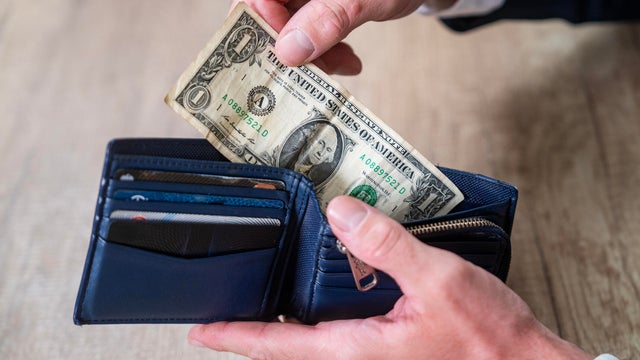 Person Handling Cash and Cards in Blue Leather Wallet 