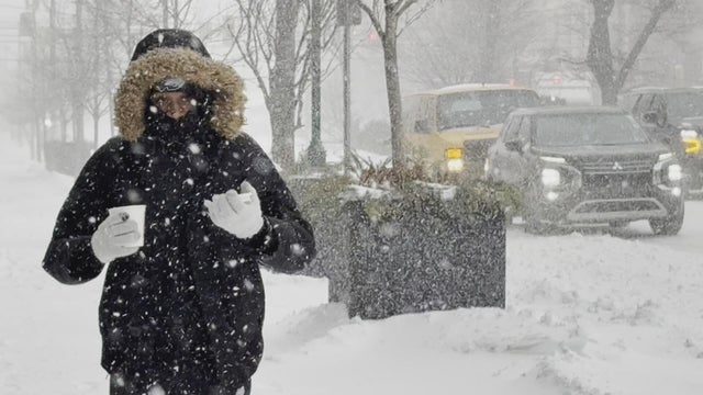 A person walks with a cup of coffee in the snow 