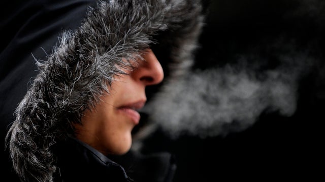 COLD02--Desiree Lopez trys to keep warm as she walks in downtown Denver. A storm moved into the metro area bring cold weather to the area. RJ Sangosti/ The Denver Post 