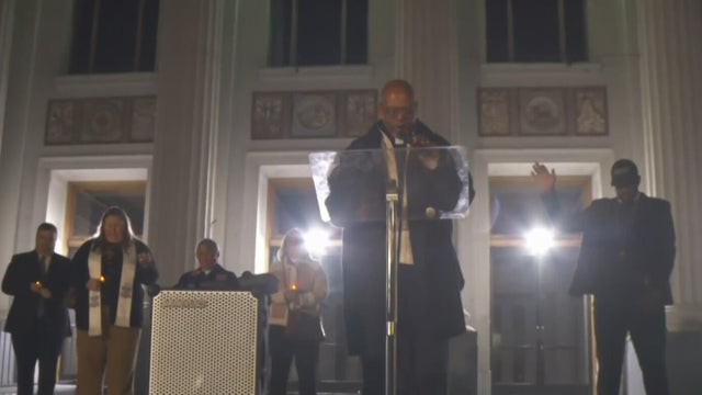 A faith leader speaking at a podium 