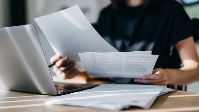 Cropped shot of young Asian woman handling personal banking and finance with laptop at home. Planning budget and calculating expenses. Managing taxes and financial bills. Wealth management. Digital banking habits. Smart banking with technology 