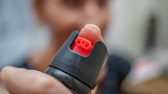 Close up of pepper spray in the girl's hand in the room 