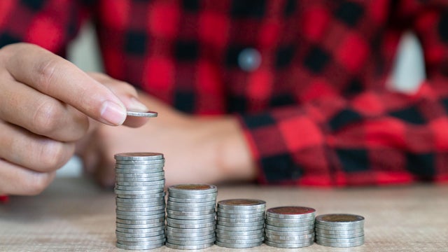 Saving money. Female hand stack coins to shown concept of growing business and wealthy. 