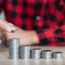 Saving money. Female hand stack coins to shown concept of growing business and wealthy. 