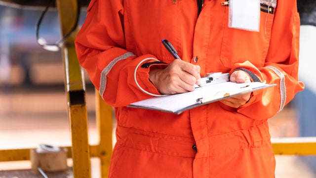 Writing note on paper - Audit and inspection in oil field operation. 