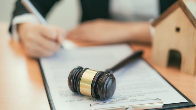 Real Estate concept, judge gavel and lawyer in auction with house model. 