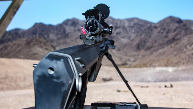 An mounted, unloaded, heavy  sniper riflea attached large scope for precision and accuracy, shooting .50 caliber cartridges with huge fire power on a shooting range 