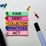 Fair Debt Collection Practices Act - FDCPA text on sticky notes isolated on office desk 