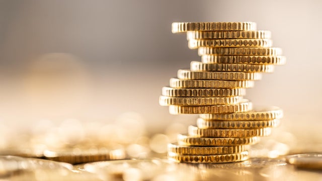 Golden Euro coins built in the shape of a tower that balances before falling, a symbol of financial growth and fall 