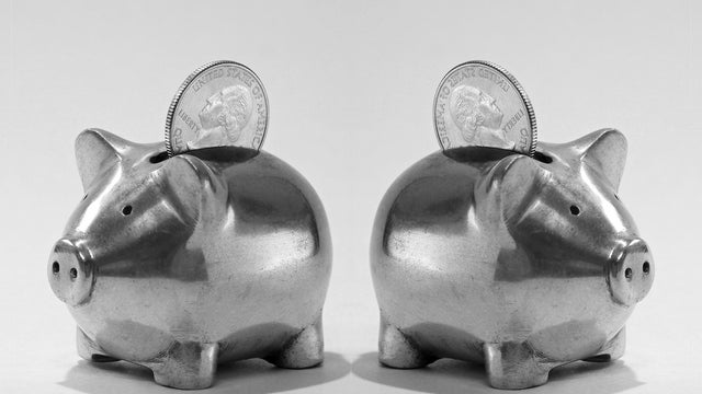Two small metal piggy banks with American quarter coins 