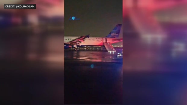 JetBlue plane on taxiway with emergency slide deployed 