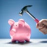 Piggy bank and hand with hammer about to smash to get at savings 