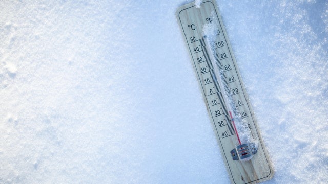 The thermometer on the snow shows low temperatures well below zero. Extreme winter freezing weather. 