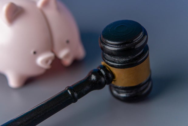 A broken pink piggy bank and a judge's gavel.