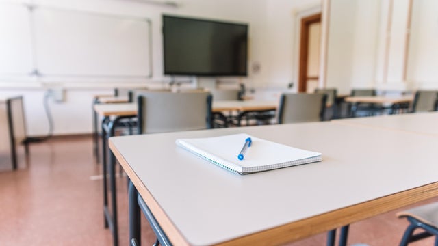 Notebook with a pen on a table in a classroom at a school 