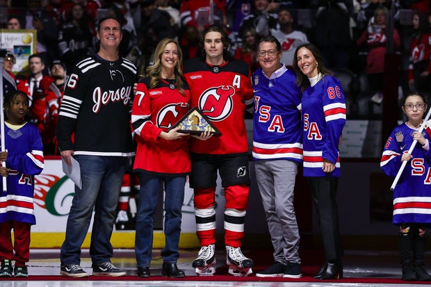 Jason Hedberg, Governor of New Jersey Mikie Sherrill, Jack Hughes #86, managing partner David Blitzer of the New Jersey Devils and Allison Blitzer pose for a photo in a pregame welcome home ceremony following the Olympics Team USA gold medal win prior to the game against the Buffalo Sabres at Prudential Center on February 25, 2026 in Newark, New Jersey. 