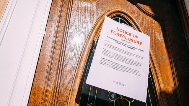 Paper Foreclosure Notice Taped to the Glass Front Door of a Home in a Residential Suburban Neighborhood 