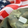Military soldier's dog tags and American flag 
