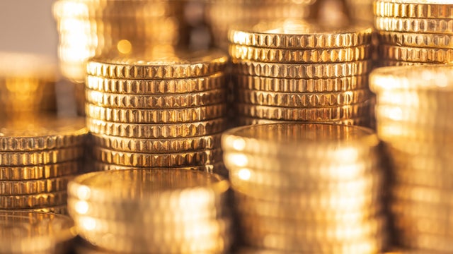 Pile of stacked shiny golden Euro coins close-up 