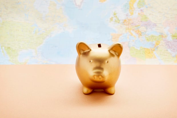Still life of a golden piggy bank against world map 