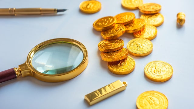 Magnifying glass and gold coins 