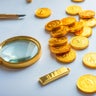 Magnifying glass and gold coins 
