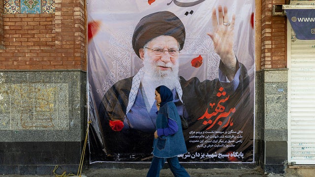 A pedestrian passes a poster of Ayatollah Ali Khamenei in Tehran on March 5, 2026. 