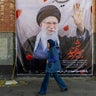 A pedestrian passes a poster of Ayatollah Ali Khamenei in Tehran on March 5, 2026. 