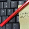 Sticky note with "Debt Collection" written on it attached to a computer keyboard. 
