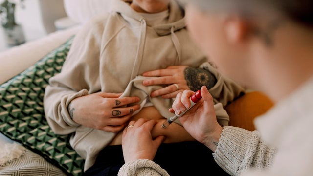 Lesbian women doing IVF test with syringe at home 