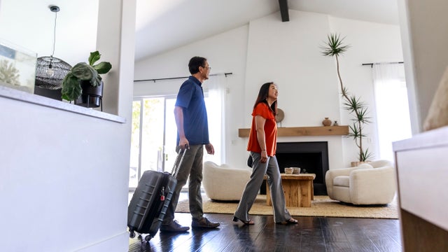 Side view of mature couple exploring living room of rental home 