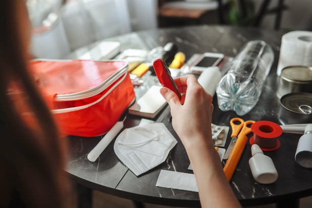 Disaster readiness at home responsible adult assembles survival kit with communication devices and matches 