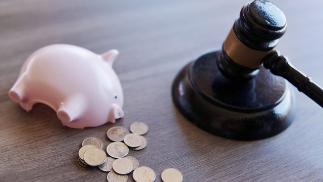 Closeup image of judge gavel and piggy bank. 