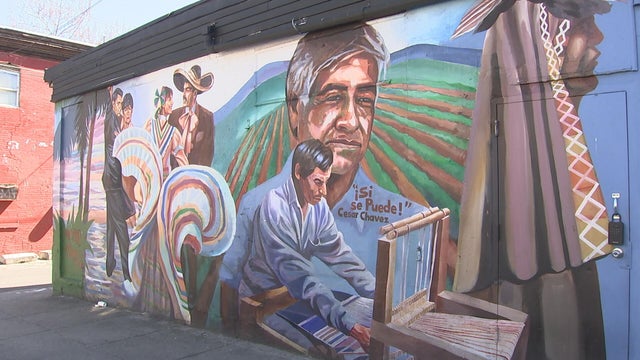 A mural depicts Cesar Chaves on a farm, it says Si se puede near his shoulder 