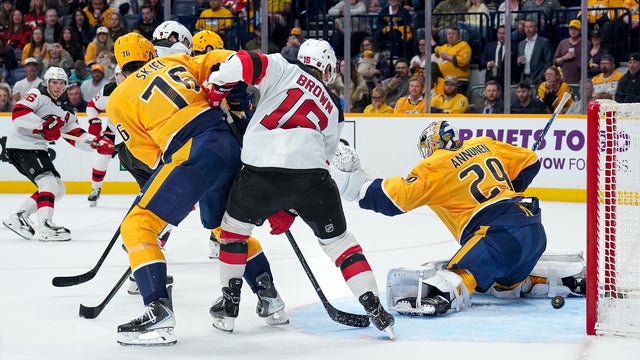 A shot by Nico Hischier #13 of the New Jersey Devils finds the net for a goal against Justus Annunen #29 of the Nashville Predators as Connor Brown #16 battles in front of the net against Brady Skjei #76 during an NHL game on March 26, 2026 in Nashville, Tennessee. 