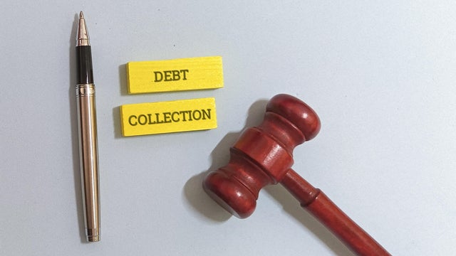Debt collection concept with gavel, pen, and notes 